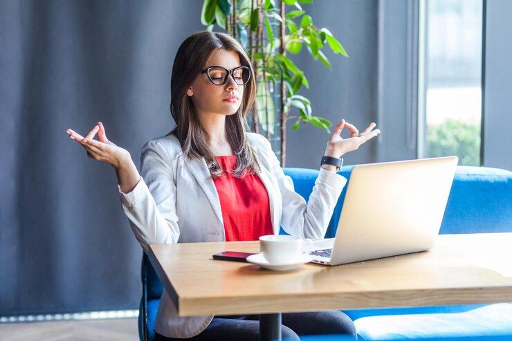 portrait-calm-beautiful-stylish-brunette-young-woman-glasses-sitting-doing-yoga-meditation-lotus-pose-with-closed-eyes-relaxed-indoor-studio-shot-cafe-office-background_416530-15216.jpg